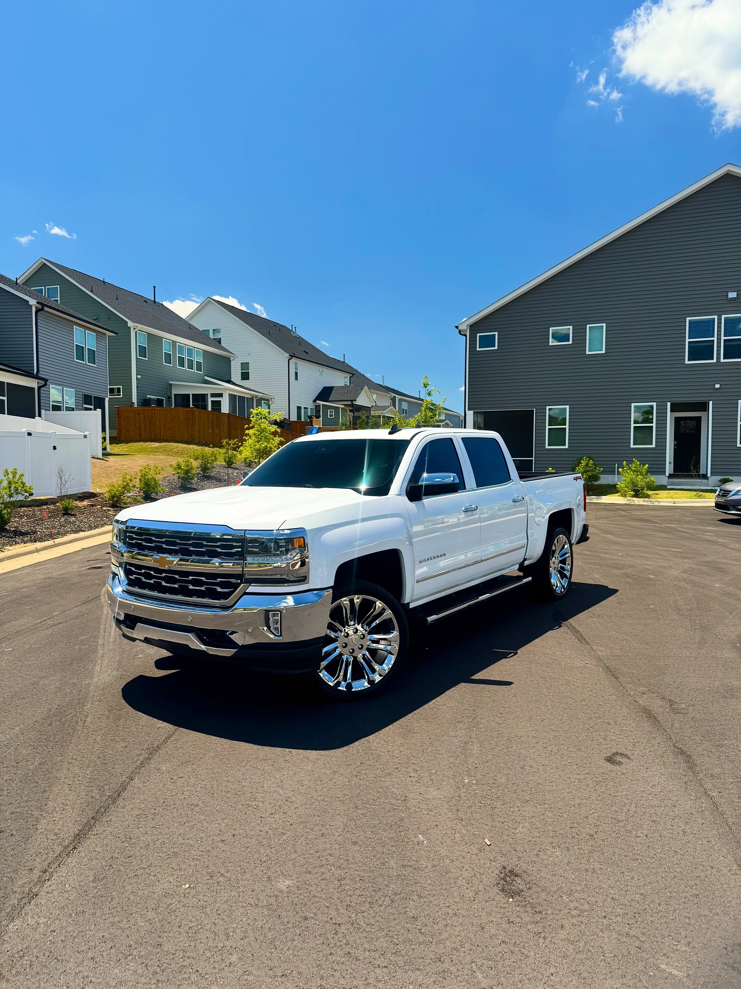 White Chevrolet Silverado with a fresh ceramic coating gleaming under blue skies in Raleigh NC
